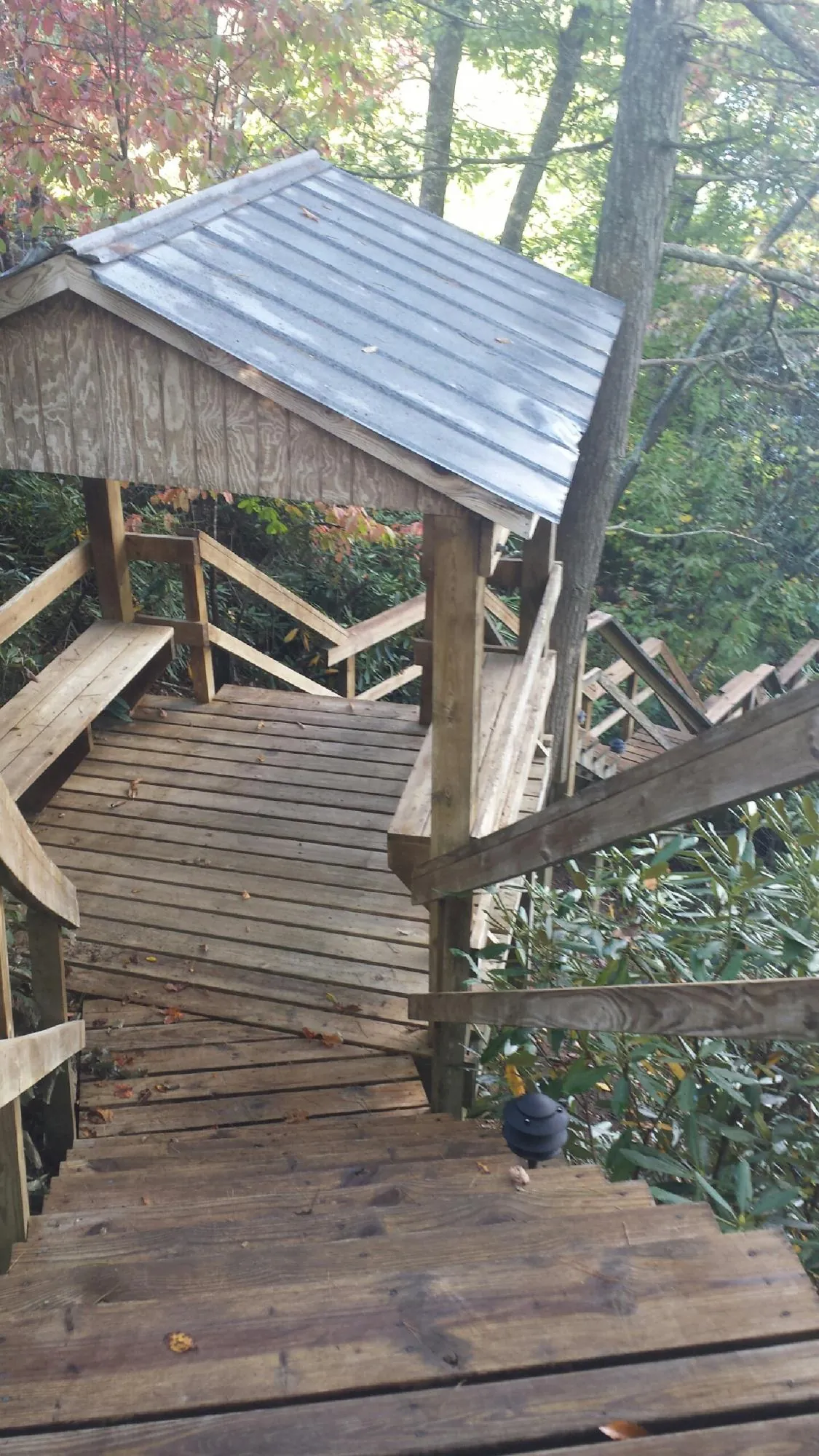 Metal roofed shelter over wooden steps on a wooded walkway — Skylight Repair & Installation work by our crew in Cutchogue