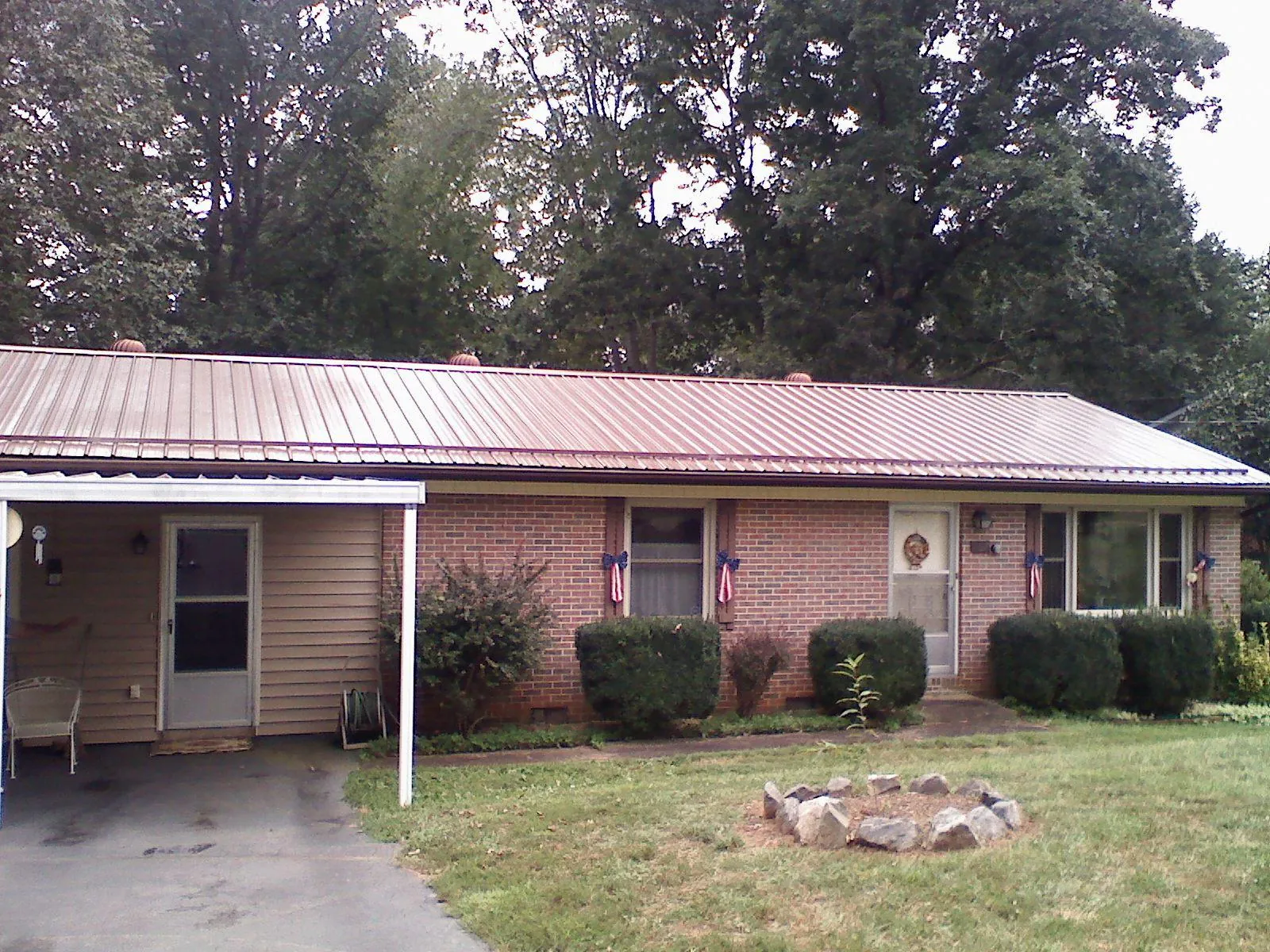 Bronze metal roof and carport on a brick ranch home — Roof Repair work by our crew in Cutchogue